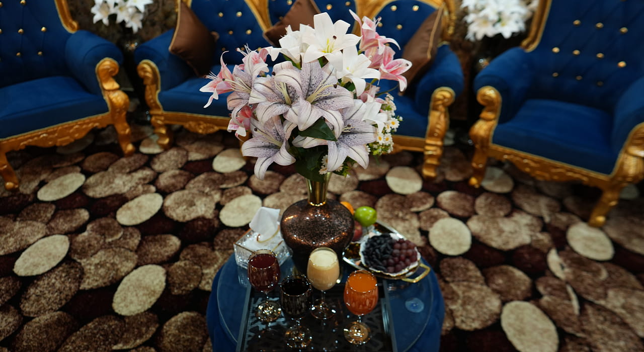 A brass bowl of oil sits beside a folded cloth and a wooden ladle on a low table.